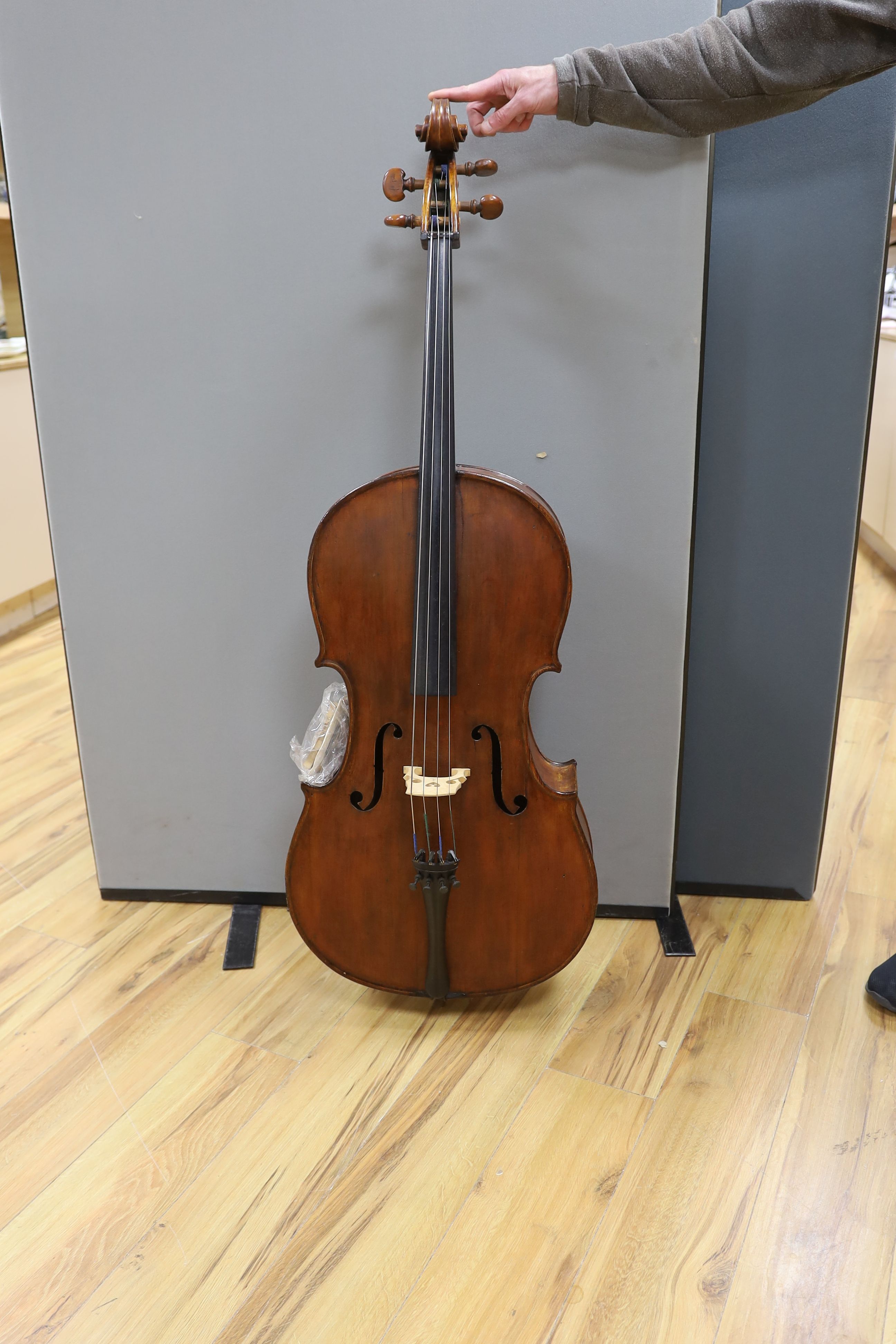 A cased early 20th century ‘cello, length of body 75.5cm, with two spare bridges, and spare strings